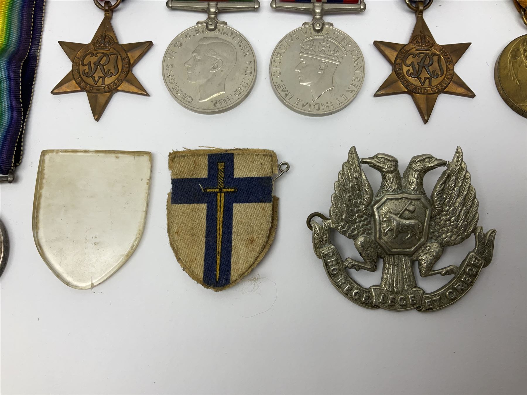 WW1 pair of medals awarded to 151761 Gnr. S. Loten R.A. with ribbons; four WW2 medals with ribbons; and small quantity of cap badges, medallions etc