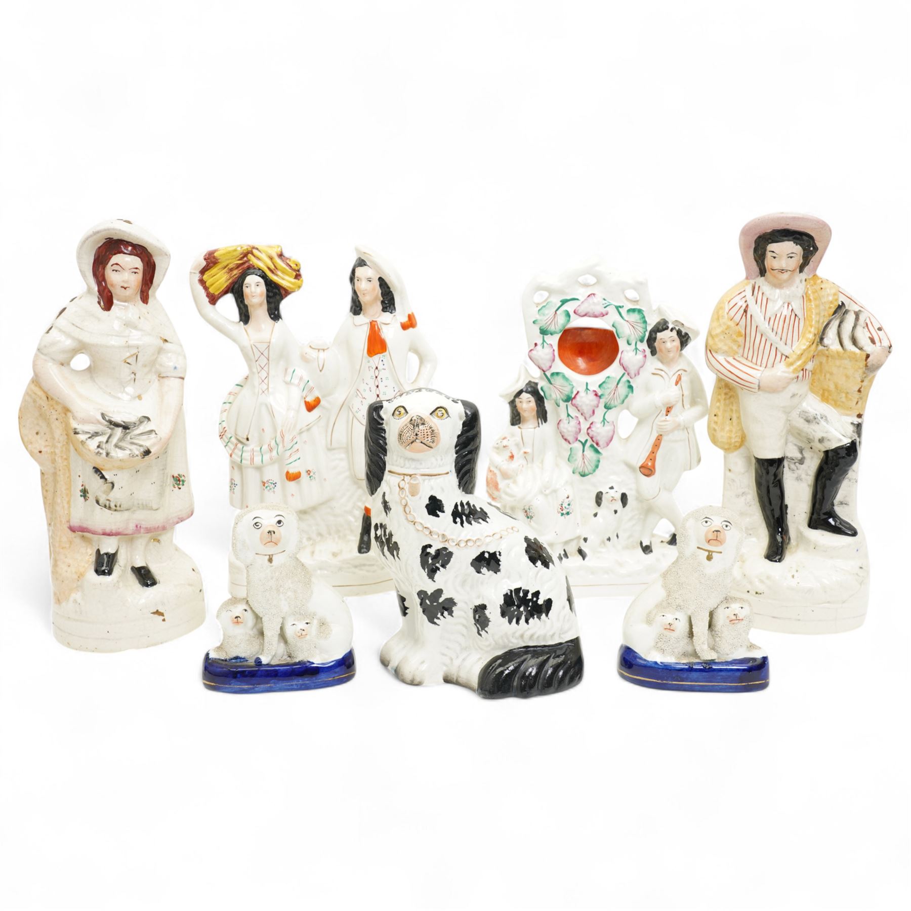 Staffordshire pottery figures including watch stand with piper and companion, pair of dogs and pups, pair of fish sellers and two others