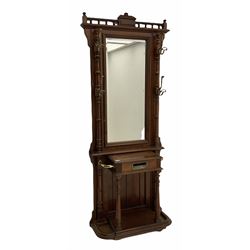Victorian style walnut and beech hall stand, the gallery top over bevelled mirror and two upright turned pilasters fitted with hooks, hinged ‘letter’ compartment flanked by two umbrella stands, shaped and moulded base