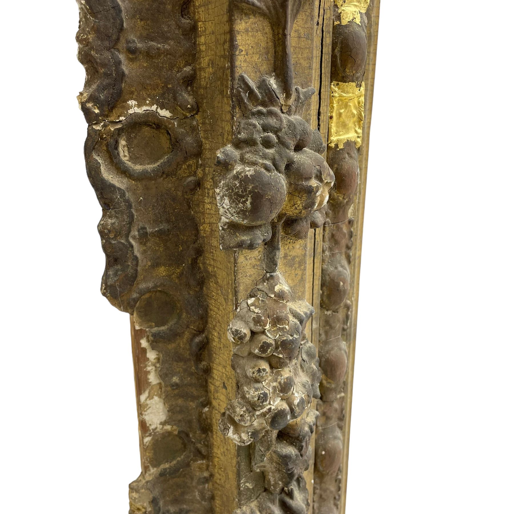 19th century giltwood and gesso moulded picture or mirror frame, the arched cresting rail mounted by central cartouche decorated with foliate scrolls and fruit, the outer frame decorated with scalloped edge and shell mouldings, trailing foliage with flower head and fruit to the central band, egg and dart moulded inner slip