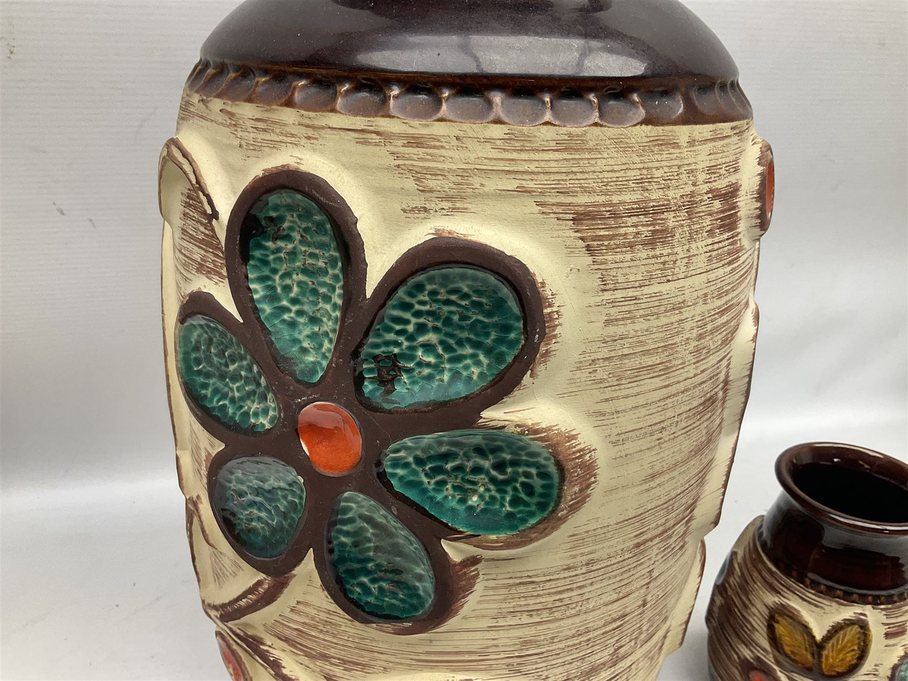 Pair of Bay West German vases, with bold moulded flower and foliage decoration in green, orange and ochre on brown ground, largest H40cm