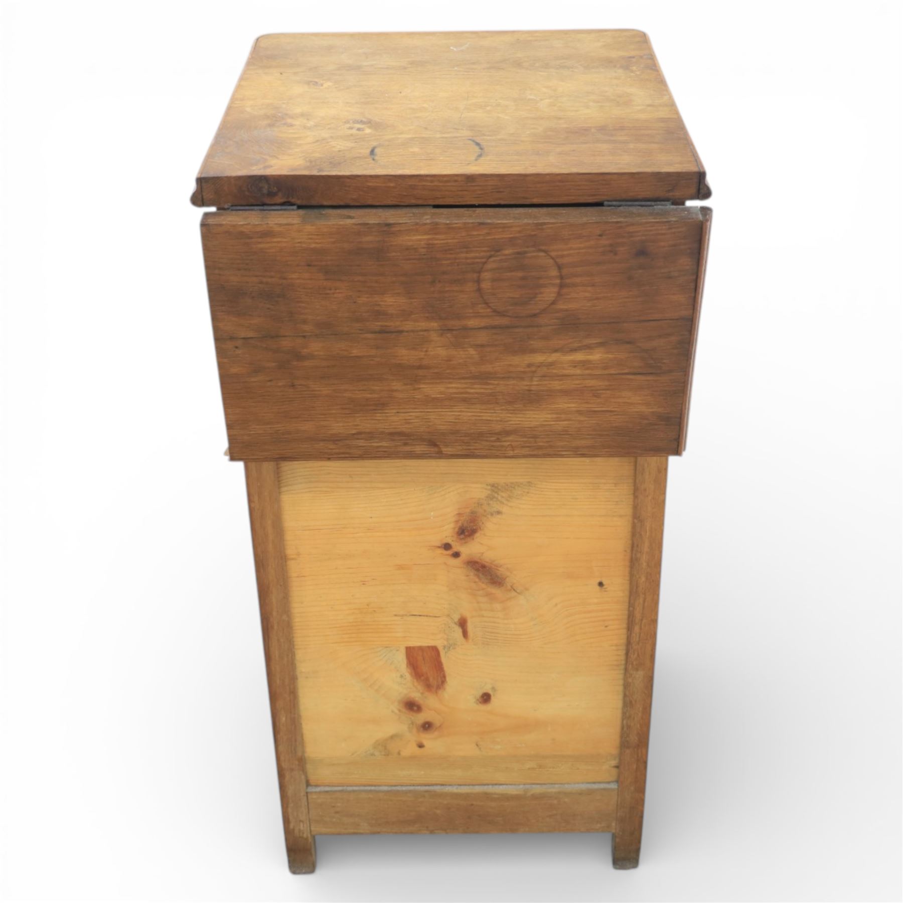20th century French style oak bedside chest of pedestal form, the top with rounded moulded edge with drop leaf to the back, above five carved drawers with applied scroll ornament and turned knobs, the cupboard base with twin carved doors with diamond lattice panels, with shaped apron and bracket feet