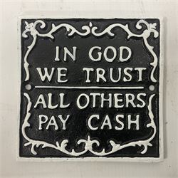 Cast iron 'In God we Trust' sign with white writing on a black ground, H15cm