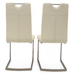 Set of seven contemporary style dining chairs, each with a high padded back and seat upholstered in faux leather on brushed steel sled bases  