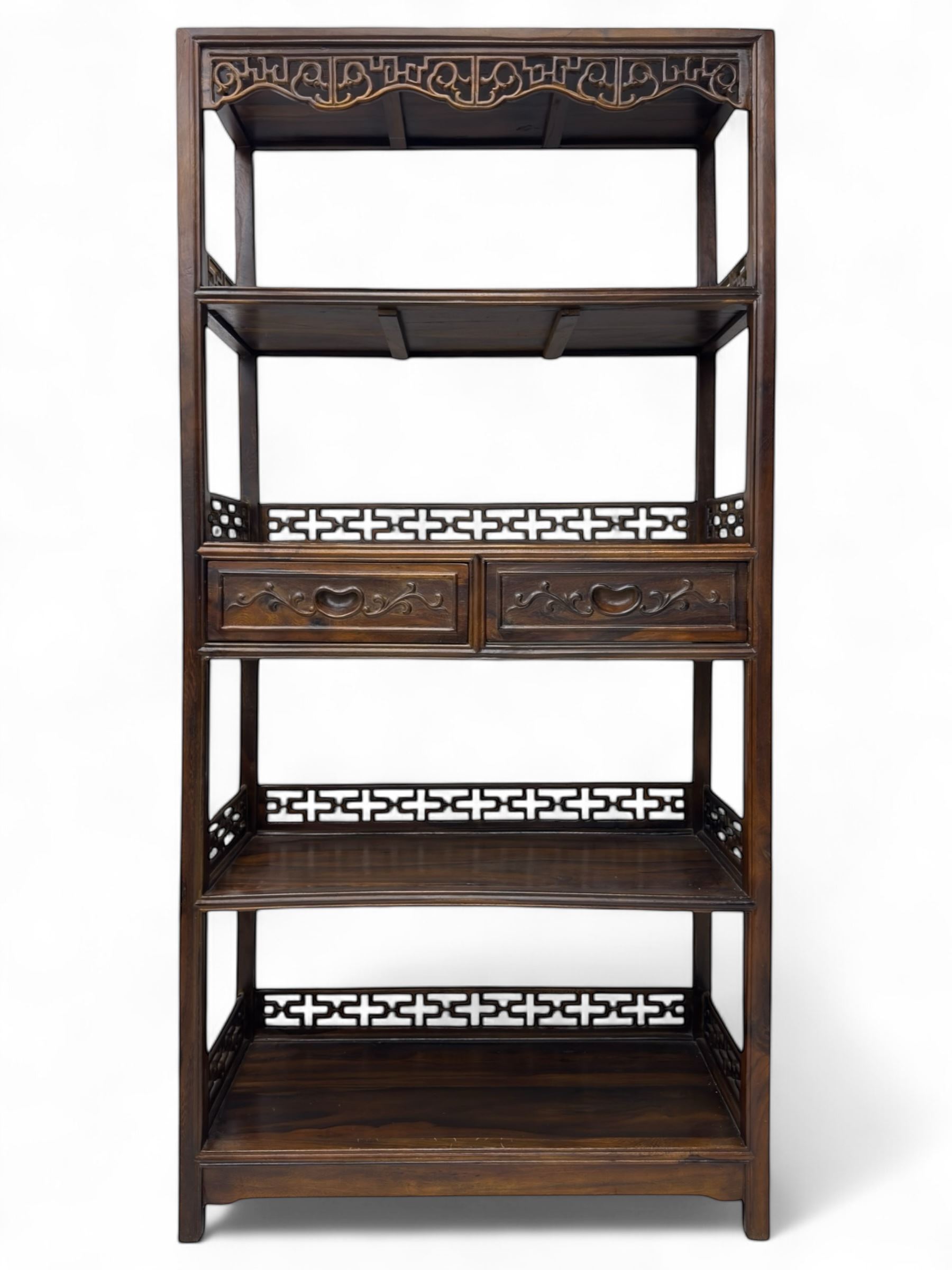 Early 20th century Chinese hardwood display étagère bookcase, the rectangular open tiered frame with pierced frieze and geometric openwork gallery to each shelf, fitted with two short drawers carved with stylised lotus motifs, supported on square uprights with pierced apron and integral gallery rails