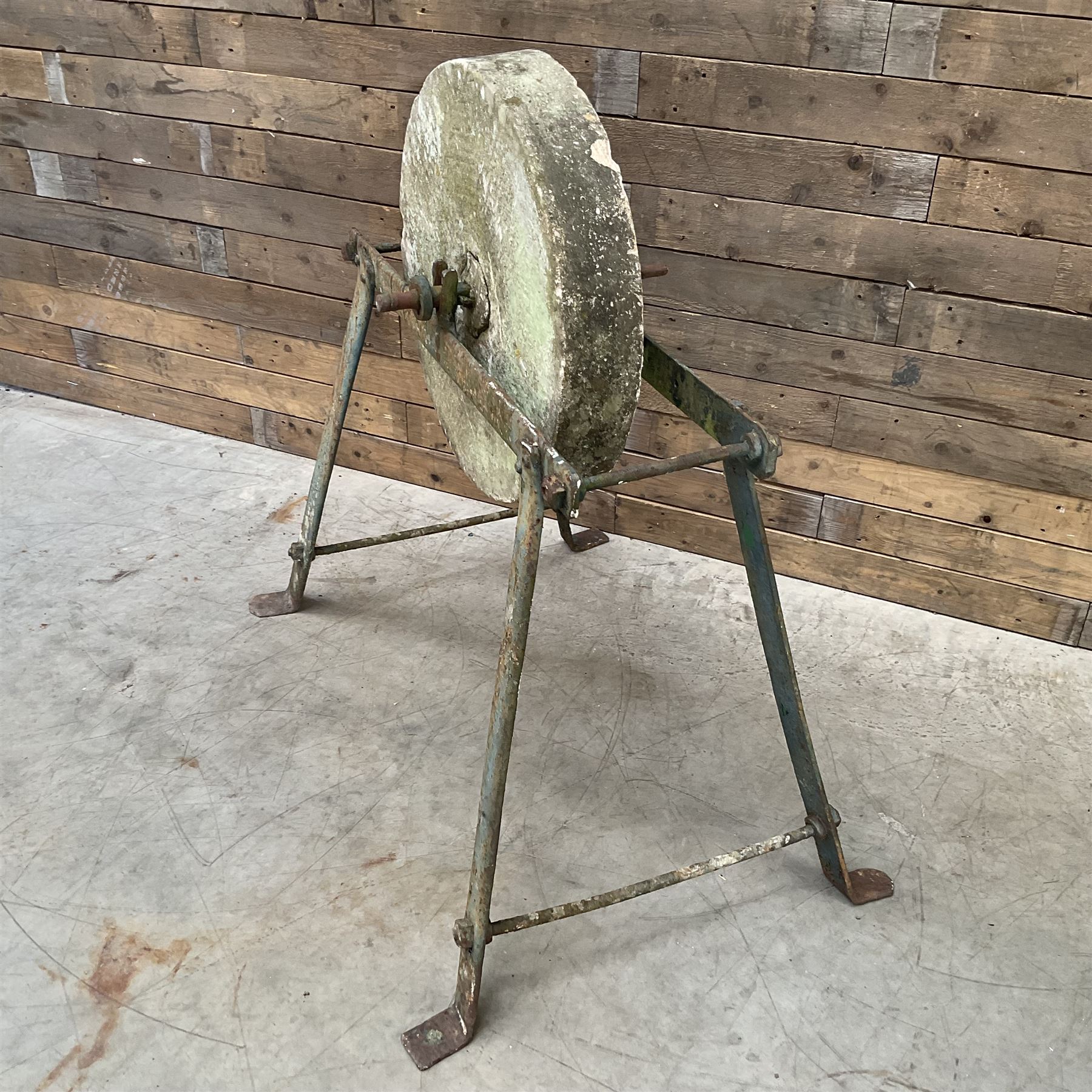 Vintage grindstone sharpening wheel mounted on metal stand, and a cast iron water pump
