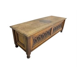 Early 20th century oak ‘bay window’ shaped blanket chest or coffer, hinged top, the front with two lunette carved panels flanked by fluted uprights, on turned feet