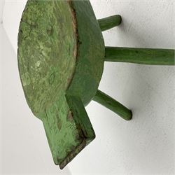 18th/19th century vernacular primitive green painted stool with dished seat fitted with metal scraper to one end, on three splayed legs, L46cm, H34cm