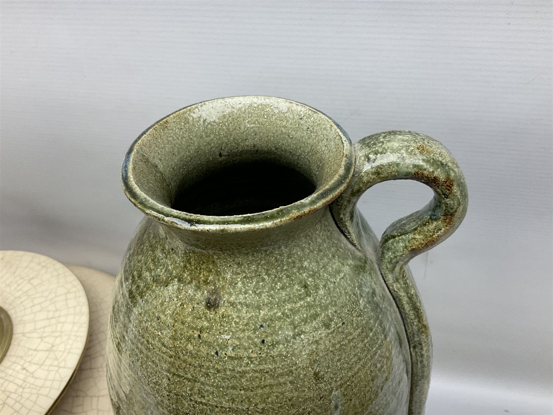 Large cream crackle glaze table lamp, together with a tall studio pottery vase in green with single loop handle, with impressed makers mark, H49cm