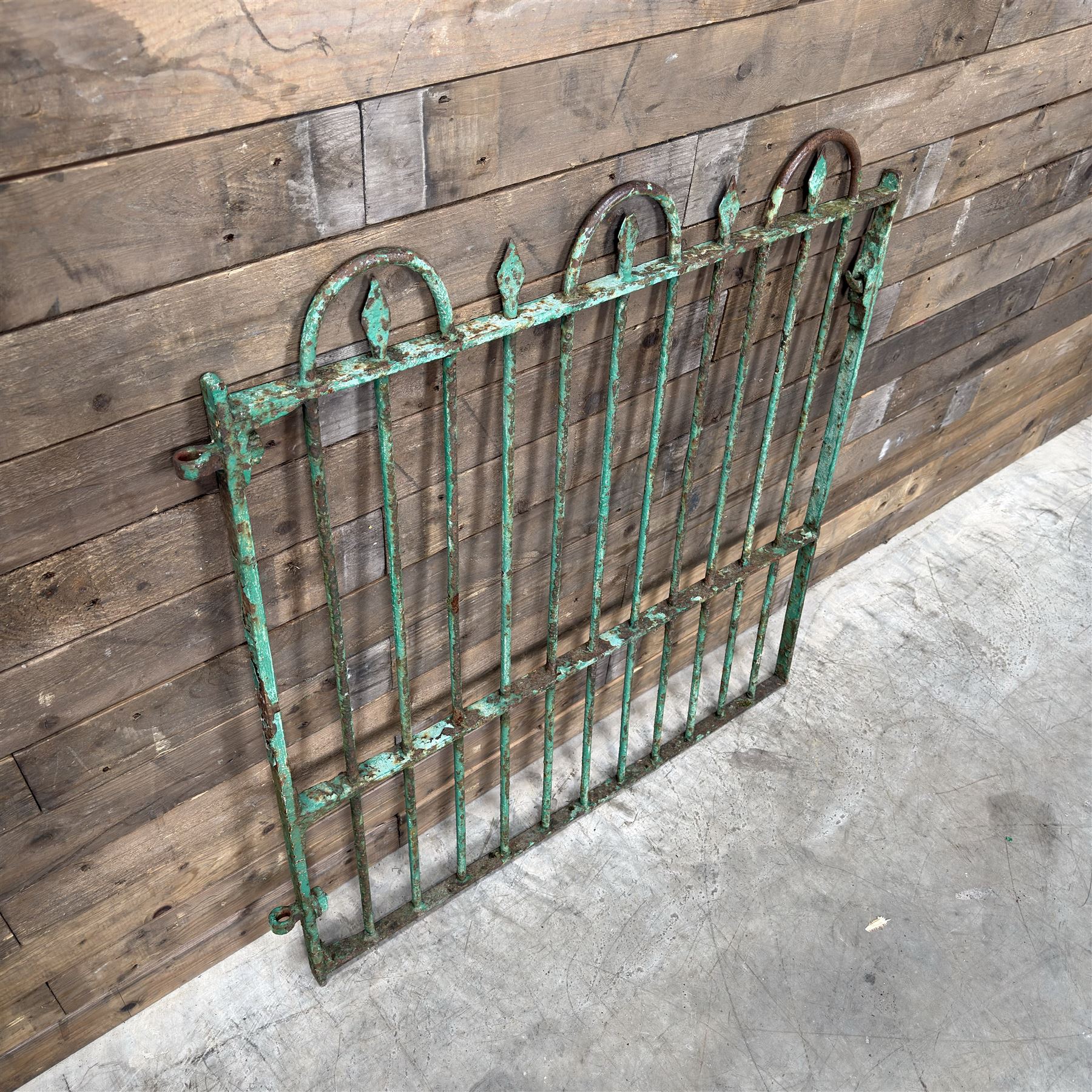 19th century French cast iron garden gate, finished in green rustic paint, bar form with hoop and spear top, with loop hinge brackets