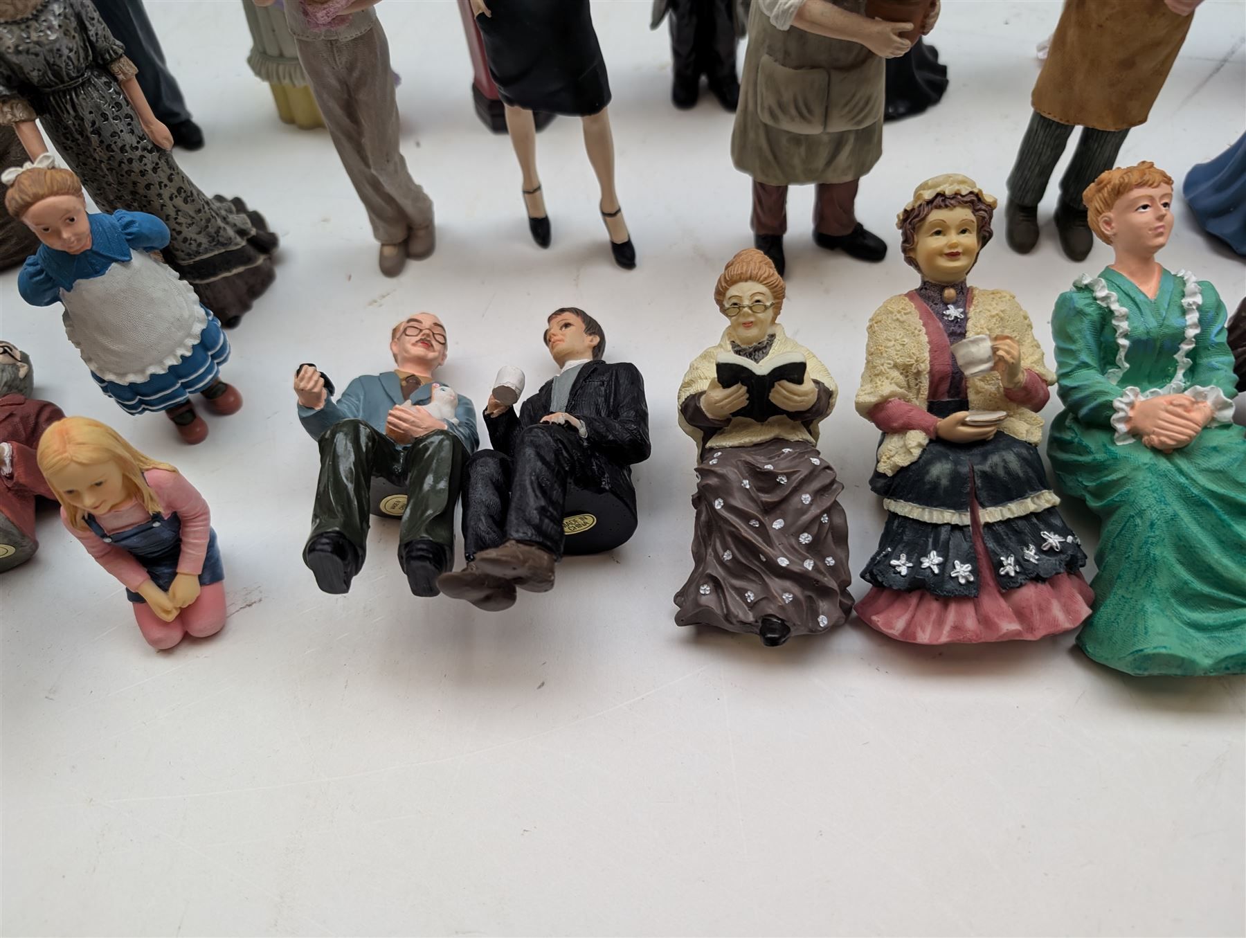 1:12 scale dolls house composite figures, including policeman, postman, maid, sitting and standing people in various styles of dress, etc