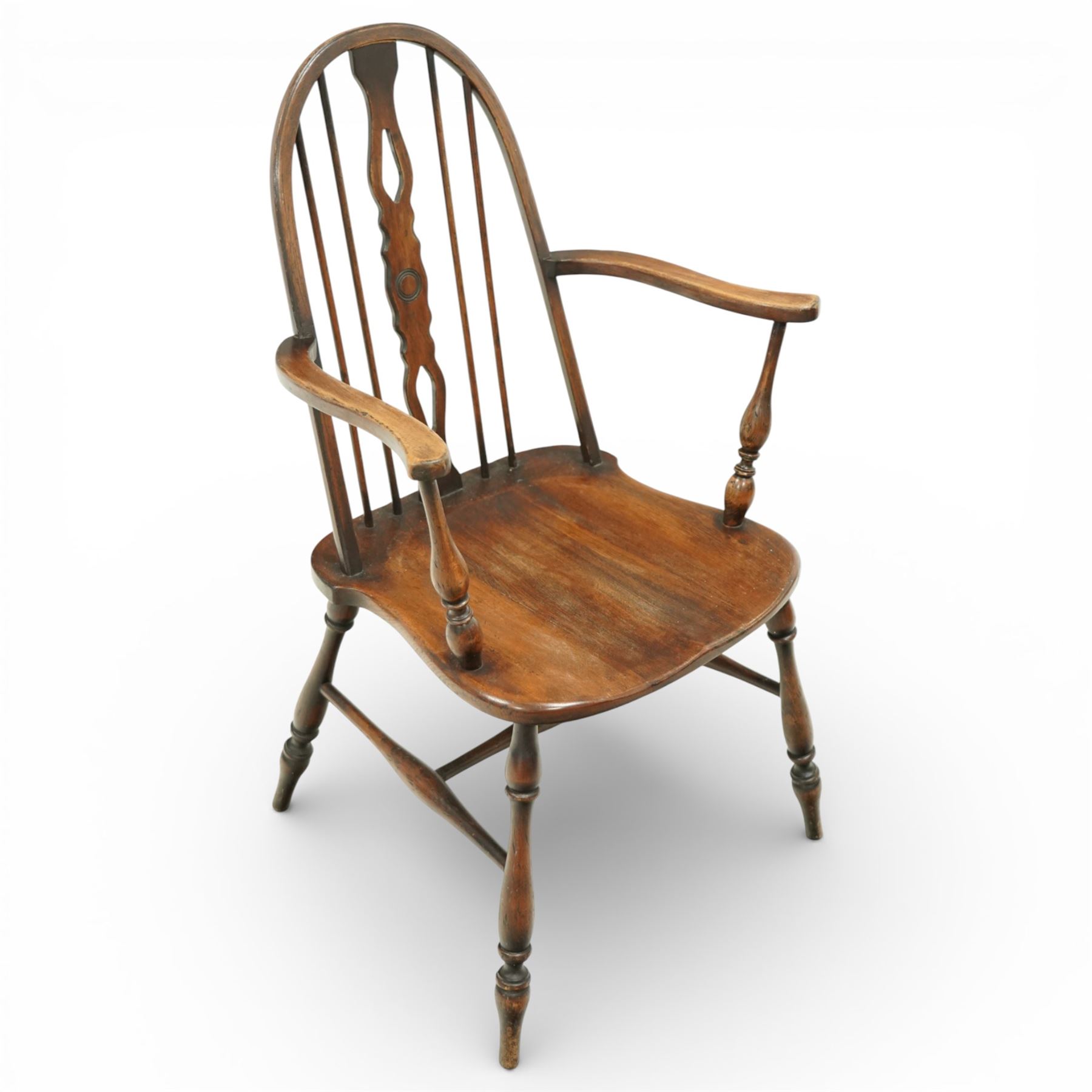 Early 20th century Windsor armchair, the arched hoop back enclosing a pierced and shaped splat flanked by turned spindles, above a shaped elm seat and outswept arms on turned supports, raised on turned legs united by an H stretcher