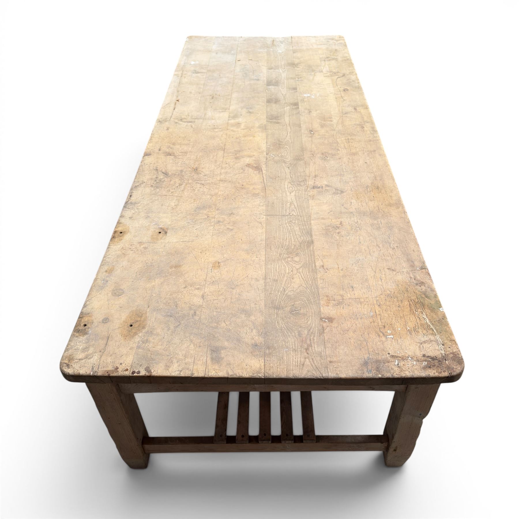 Large early/mid-20th century pine table or work bench, rectangular six plank top on eight tapering supports joined by slatted undertier