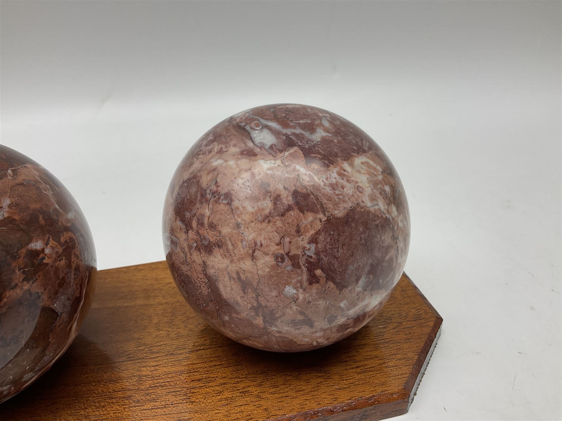 Set of three marble spheres on a elongated octagonal wooden base, H12cm