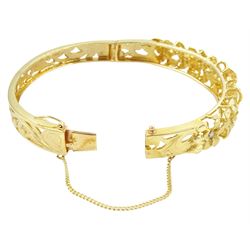 14ct gold diamond flower head hinged bangle, seven graduating flowers, each set with a single round brilliant cut diamond, to a pierced and engraved foliate body, stamped