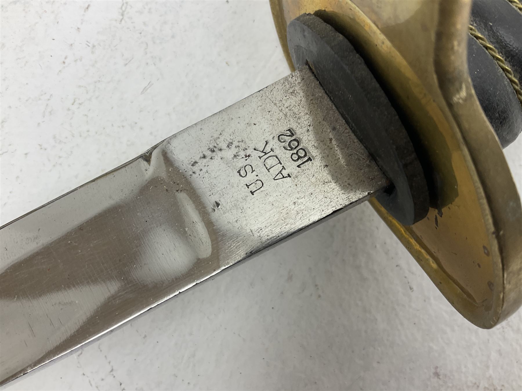 Reproduction American Civil War Cavalry trooper's sword, the 88cm slightly curving fullered steel blade marked to the ricasso 'Ames & Co Chicopee Mass.' and 'US ADK 1862'; brass hilt and leather covered grip; in steel scabbard L110cm overall;  and another reproduction sword (2)