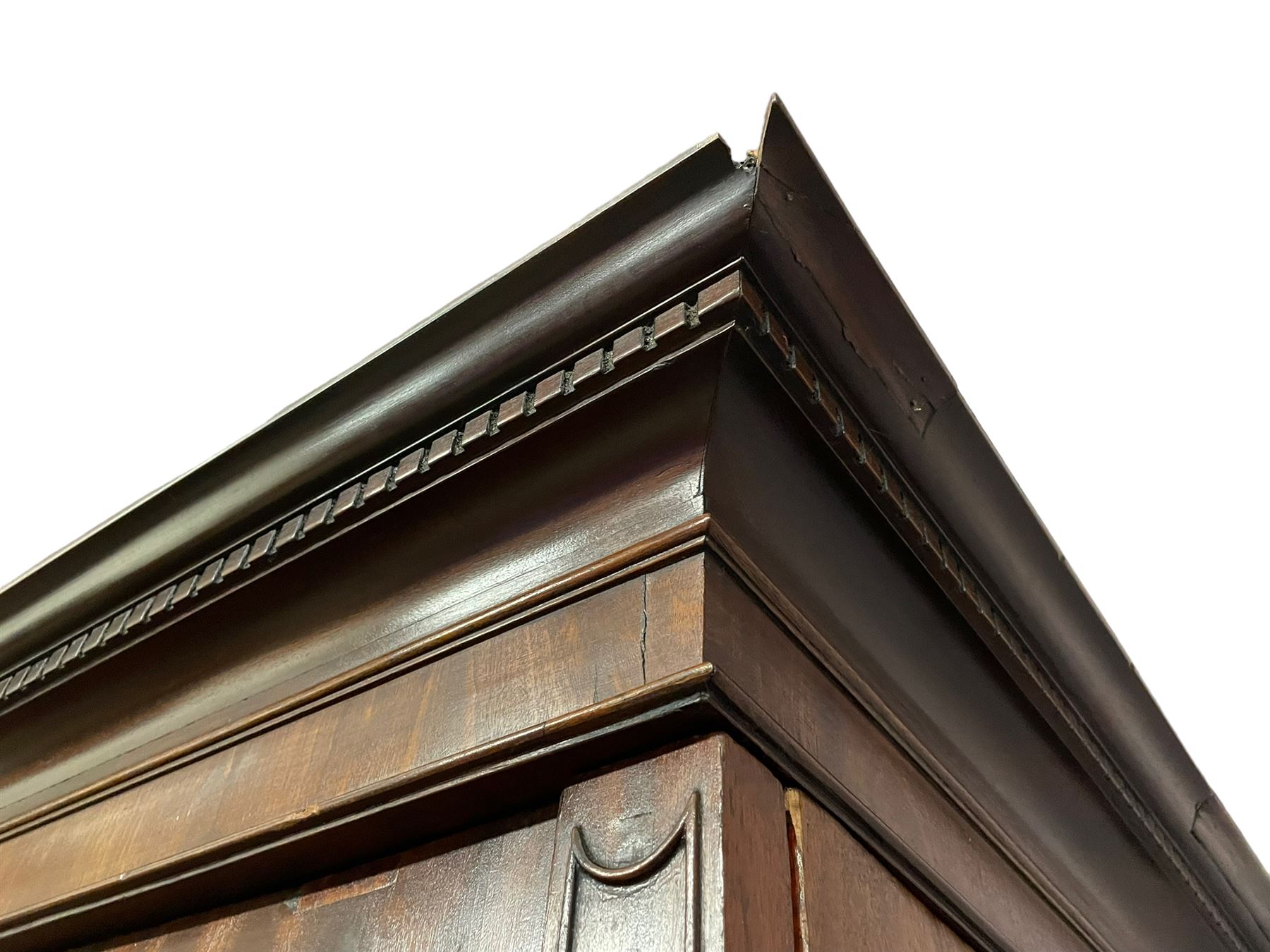 George III mahogany double wardrobe, the projecting cornice with dentil moulding over two panelled doors with mirror-lined interiors, enclosing hanging rails and brass hooks, the base fitted with two drawers, raised on bracket feet