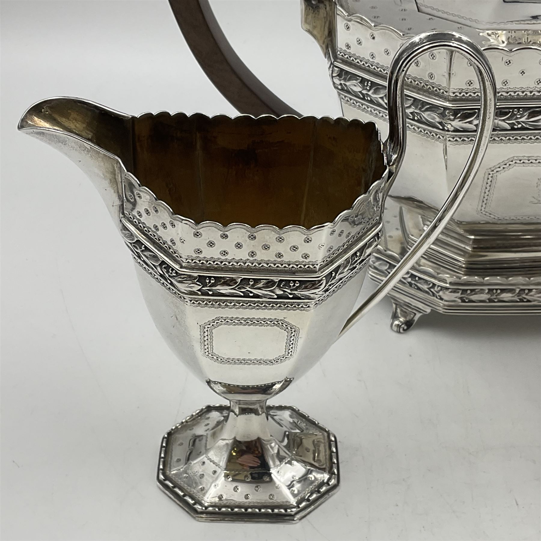Victorian silver four piece tea service, comprising teapot, teapot stand, twin handled open sucrier and milk jug, each of octagonal form with foliate bud border and engraved decoration including crest to canted panels, and vacant panels, the teapot with ivory finial to the hinged cover and later wooden handle, hallmarked Edward Barnard & Sons Ltd, London1896, teapot including finial H15cm, milk jug including handle H16cm, teapot stand W11.5cm

This item has been registered for sale under Section 10 of the APHA Ivory Act