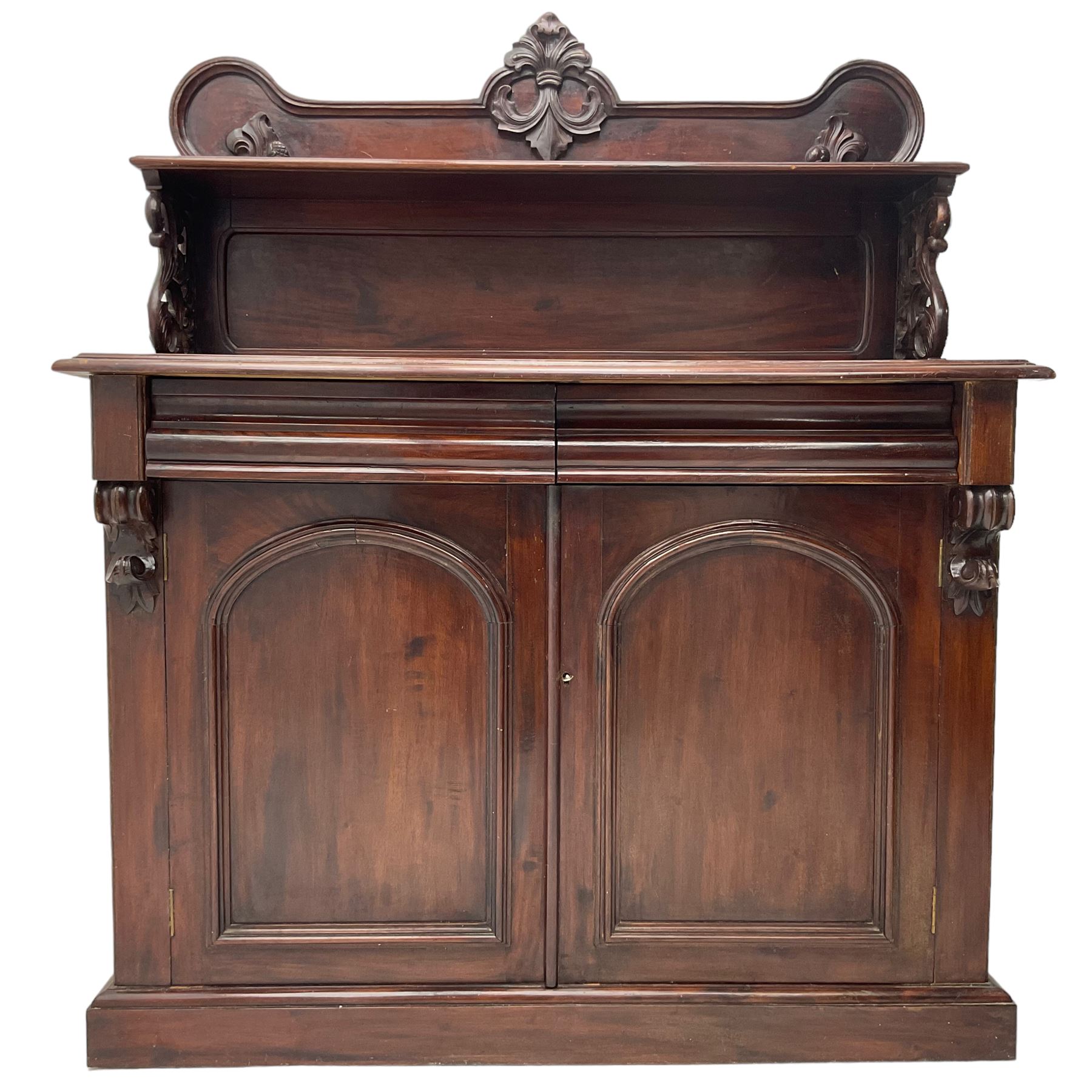 Victorian mahogany chiffonier, raised shaped back with foliage scroll carved mounts, on fretwork and carved bracket supports, moulded rectangular top over two frieze drawers and double panelled cupboard, on moulded plinth base