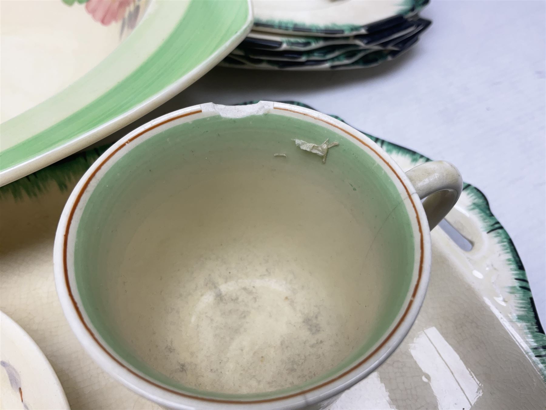 Clarice Cliff for Newport Pottery Corolla pattern tea and dinner wares, comprising triangular bowl, four side plates, two shallow bowls and teacup (a/f), together with a Clarice Cliff Wilkinson twin handled soup bowl and unassociated saucer both decorated with pink and yellow flowers, together with other mid century ceramics comprising Parrott and Company Coronet Ware, and Royal Staffordshire AJ. Wilkinson Ltd dinner wares
