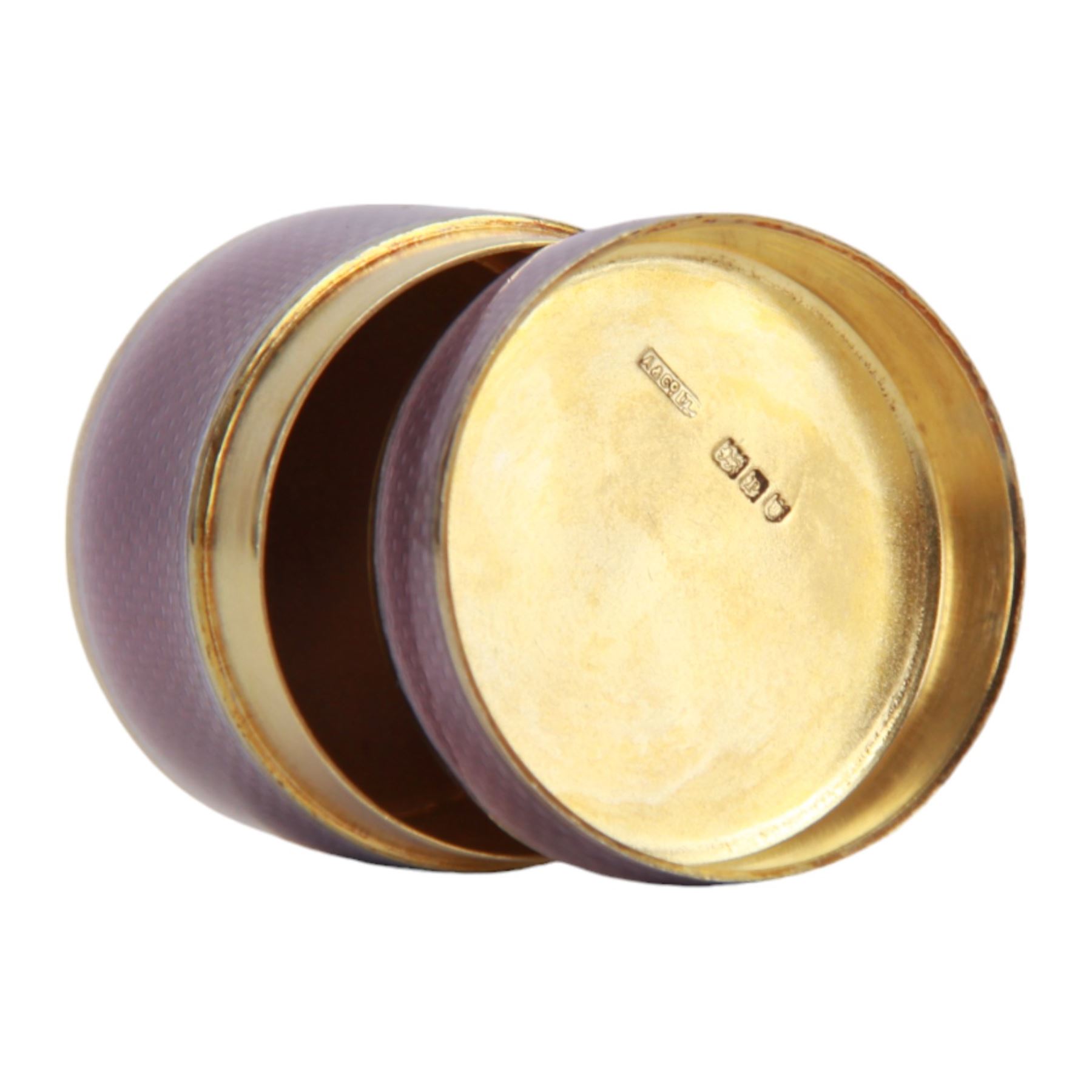 Small early 20th century silver gilt and lilac guilloche enamel box, of cylindrical form, the cover lifting to reveal a gilt interior, hallmarked Asprey & Co Ltd, London 1910, H2.5cm D4cm