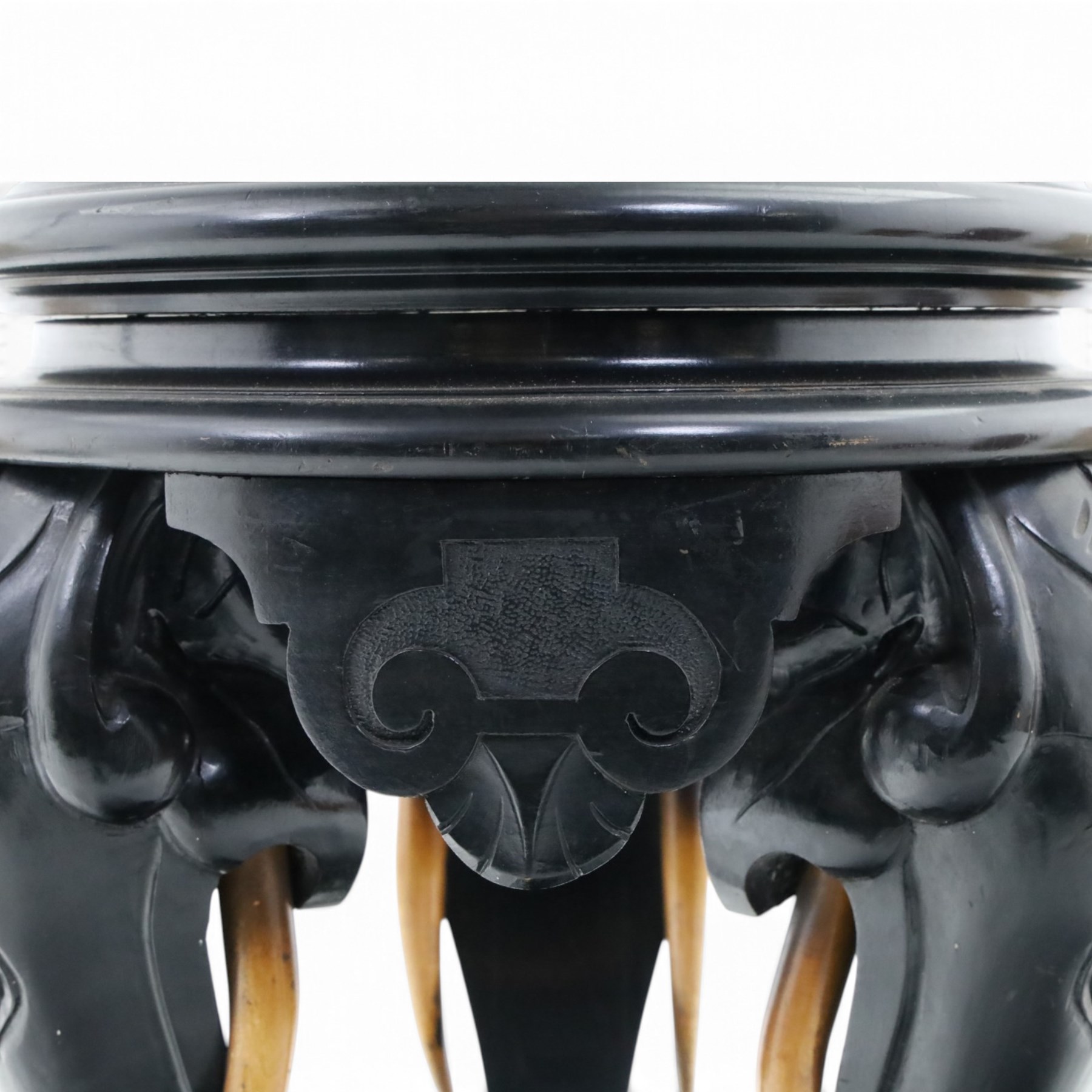 Elephant ebonised jardinière, moulded circular top raised on carved Elephant supports united by a shaped undertier