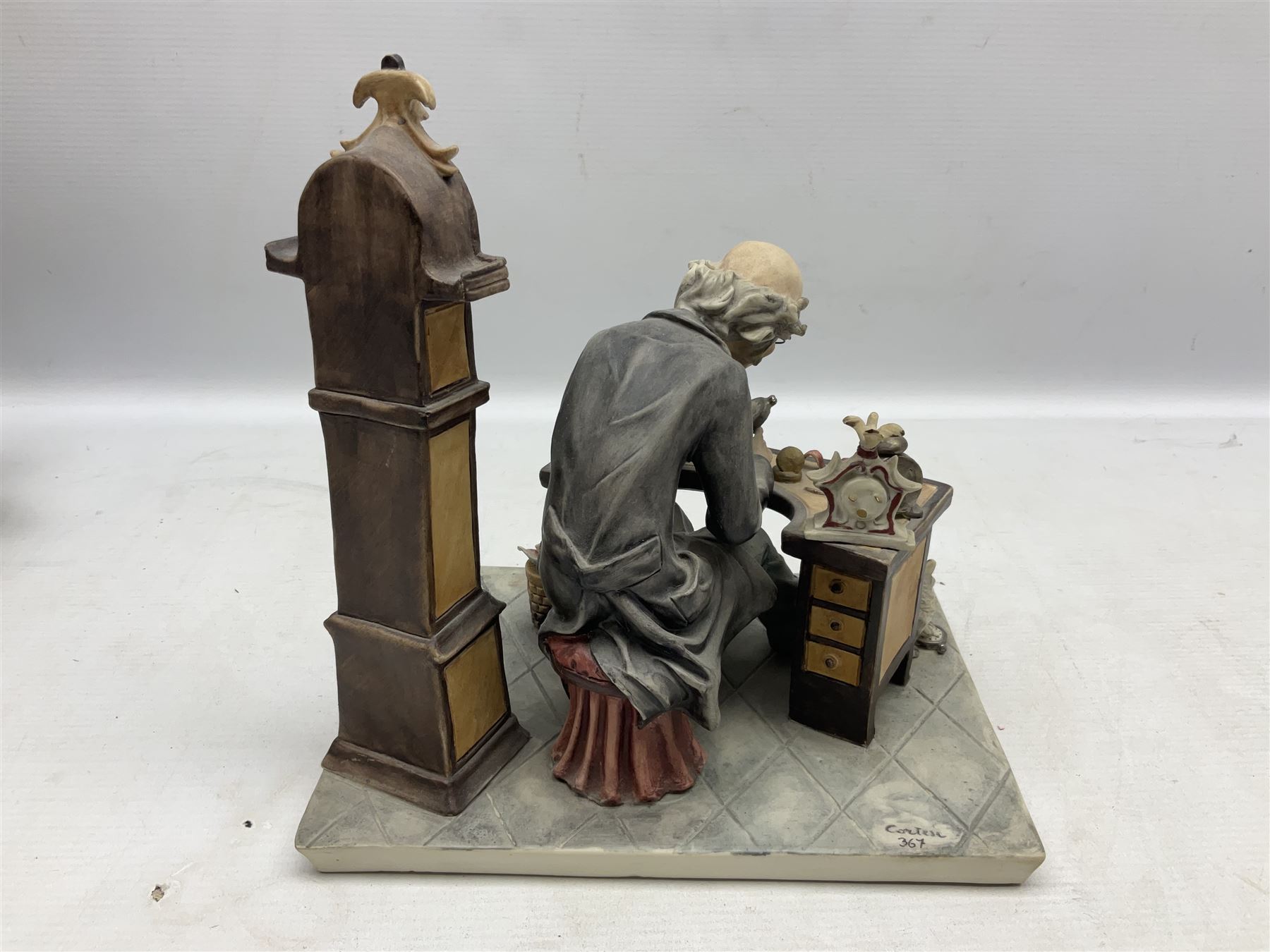 Two Capodimonte figures, comprising The Watchmaker by Curiase and Tramp Seated on a Bench, created by D.Bonalberti, tallest example H24cm