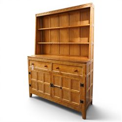 Rabbitman - adzed oak Welsh dresser, scalloped cornice above two plate racks, adzed and panelled sides, the lower integrated section with adzed oak top, over two drawers above twin cupboard doors with blackened metal latch and hinges, carved rabbit to the right hand side, by Peter Heap of Wetwang