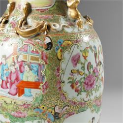 Cantonese famille rose vases, of inverted baluster form, the domed cover with gilt dog of Fu finial, H38cm; together with a further pair of Cantonese vases, each with double Buddhist lion handles and applied at the shoulders with chilong, H45cm (3)
