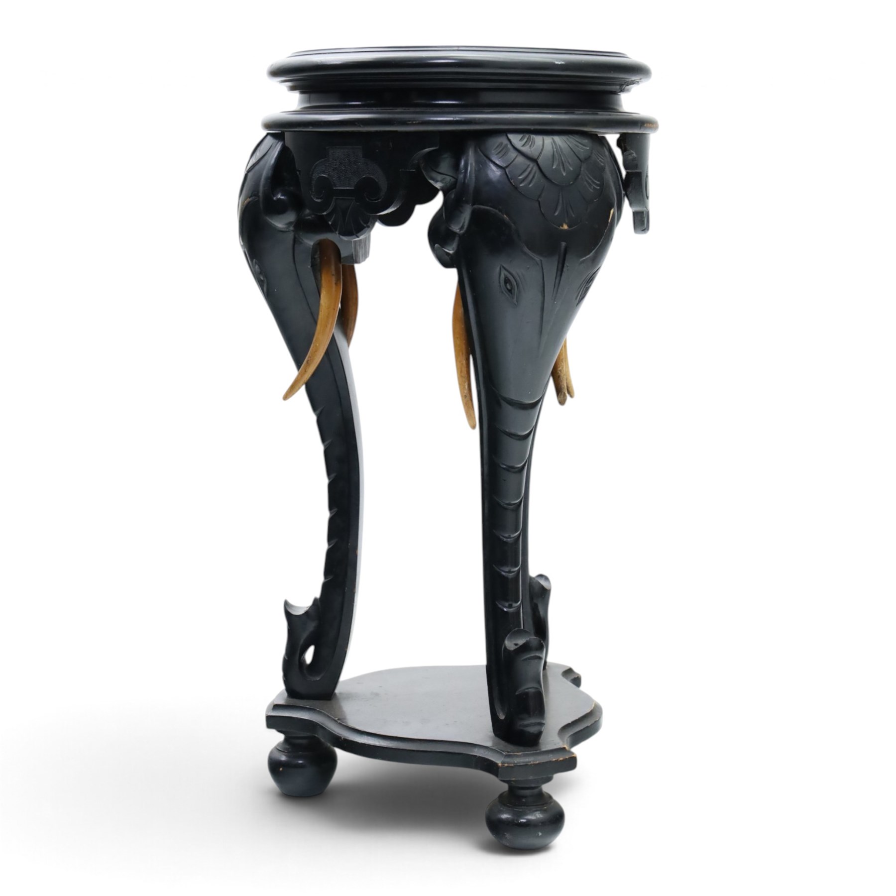 Elephant ebonised jardinière, moulded circular top raised on carved Elephant supports united by a shaped undertier