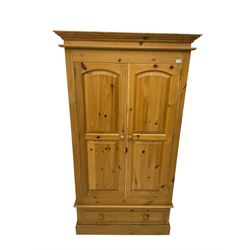 Solid pine double wardrobe enclosed by two panelled doors over single drawers