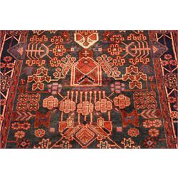 Persian Hamadan runner rug, the indigo ground decorated with stylised flowering plants and geometric motifs in crimson, rose and ivory, enclosed by an indigo flowerhead border and narrow red guard stripes