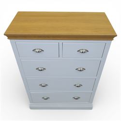 Modern chest of two short and three long drawers in white finish with oak moulded top, with metal cup handles, raised on a moulded plinth base