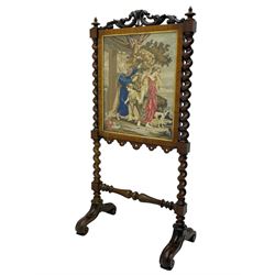 Victorian rosewood fire screen, scrolled foliage carved pediment, rectangular frame with moulded gilt slip enclosing figural needlework tapestry panel, on spiral turned supports with finials united by turned lower stretcher, on out-splayed feet with scroll carved terminals 