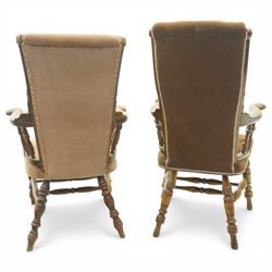 Near pair of late 20th century oak high back armchair, upholstered in brown fabric with buttoned back and close-nailed borders, shaped arms on turned supports, over a stuff-over seat, raised on turned legs united by stretchers