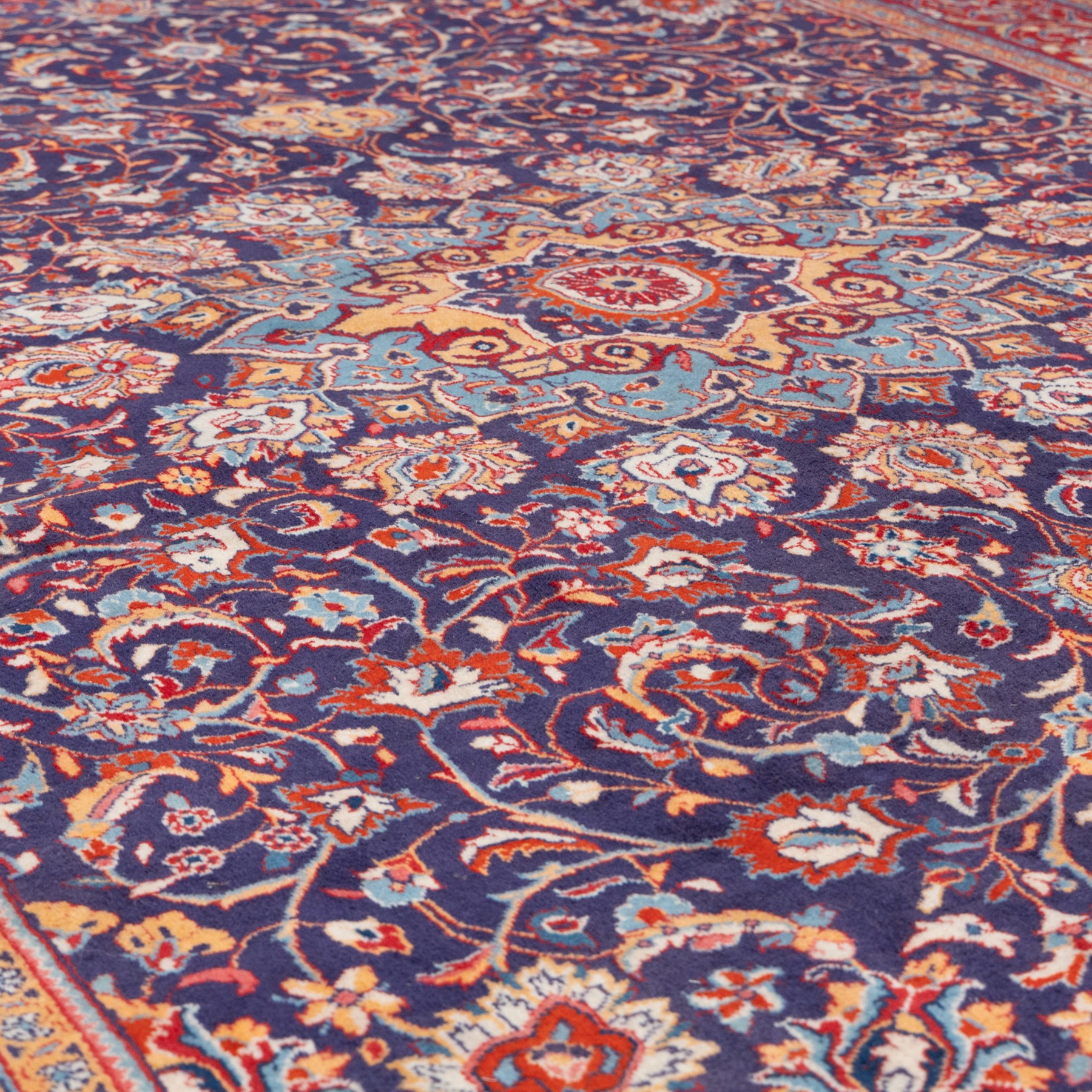 North West Persian carpet, the indigo field centred by a lobed medallion in pale blue and ochre with floral pendants, profusely decorated with scrolling foliage, palmettes and flowerheads, ivory floral spandrels, enclosed by a red ground palmette border and multiple floral guard bands