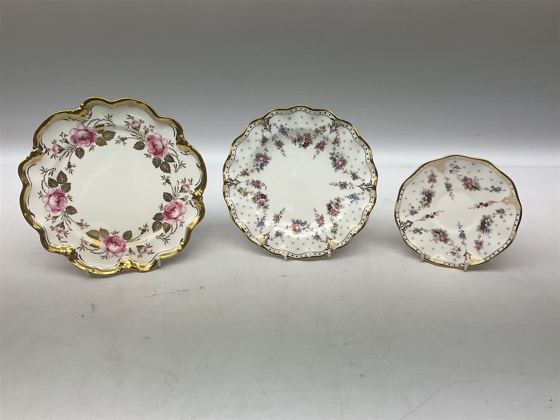 Coalport Revelry pattern tea and dinner wares, comprising nine dinner plates, four salad plates, eleven side plates, sauce boat and stand, ten teacups and ten saucers, and preserve pot and cover, together with a Coalport plate of shaped form decorated with pink roses, and a Royal Crown Derby Royal Antoinette pattern trio