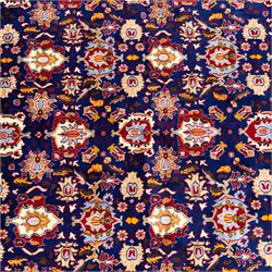 North Central Persian Veramin hand-knotted rug, deep indigo field decorated with an all-over lattice of stylized floral and palmette motifs issuing from an angular vine ornament, enclosed by a broad madder-red border of palmettes and scrolling vine devices between multiple guard stripes, with cotton fringe ends 