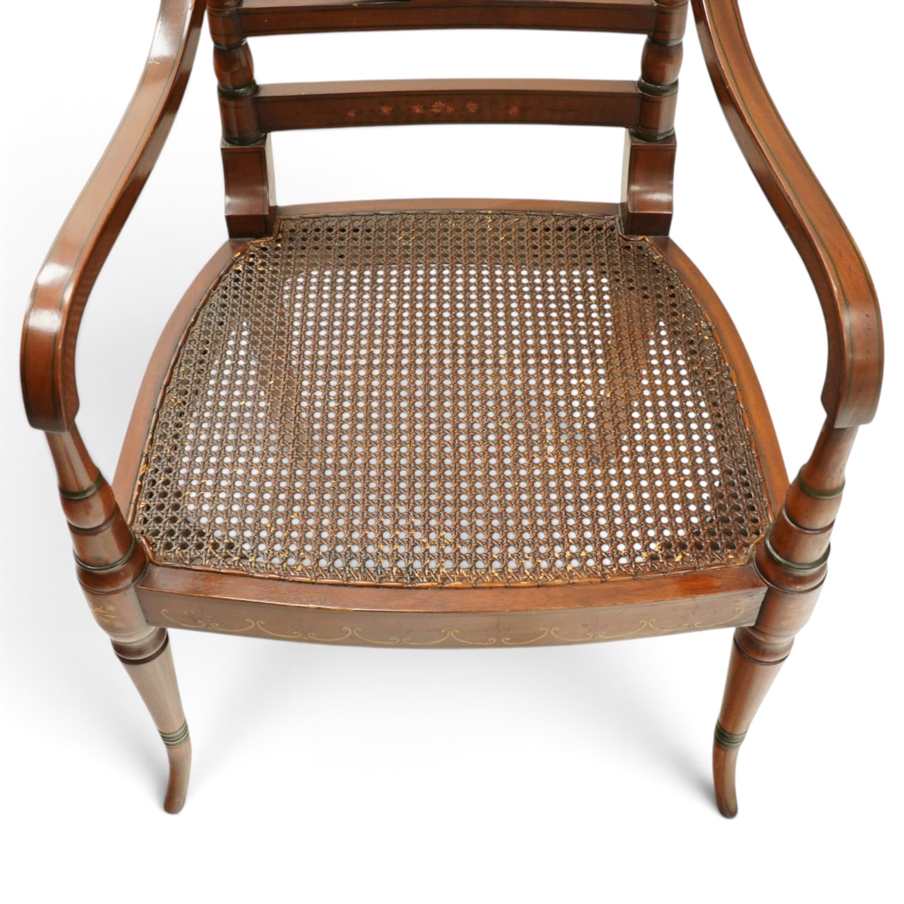 Pair of Sheraton Revival painted mahogany open armchairs, scrolled cresting rail with floral painted decoration over a double-caned back and rose-branch painted back bar, cane seat over C-scroll-painted seat rail, on splayed tapering supports, with all-over painted ebony faux stringing