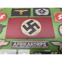 Framed display of thirty-four WWII German cloth badges including Luftwaffe pilot, Paratrooper, Afrikakorps cuff title, sleeve insignia for 'SS' Foreign Volunteers, various breast eagles including Luftwaffe, Army etc, RAD badges, Party Armband, rank and trade insignia, cap insignia etc; 40 x 50cm in modern pine frame