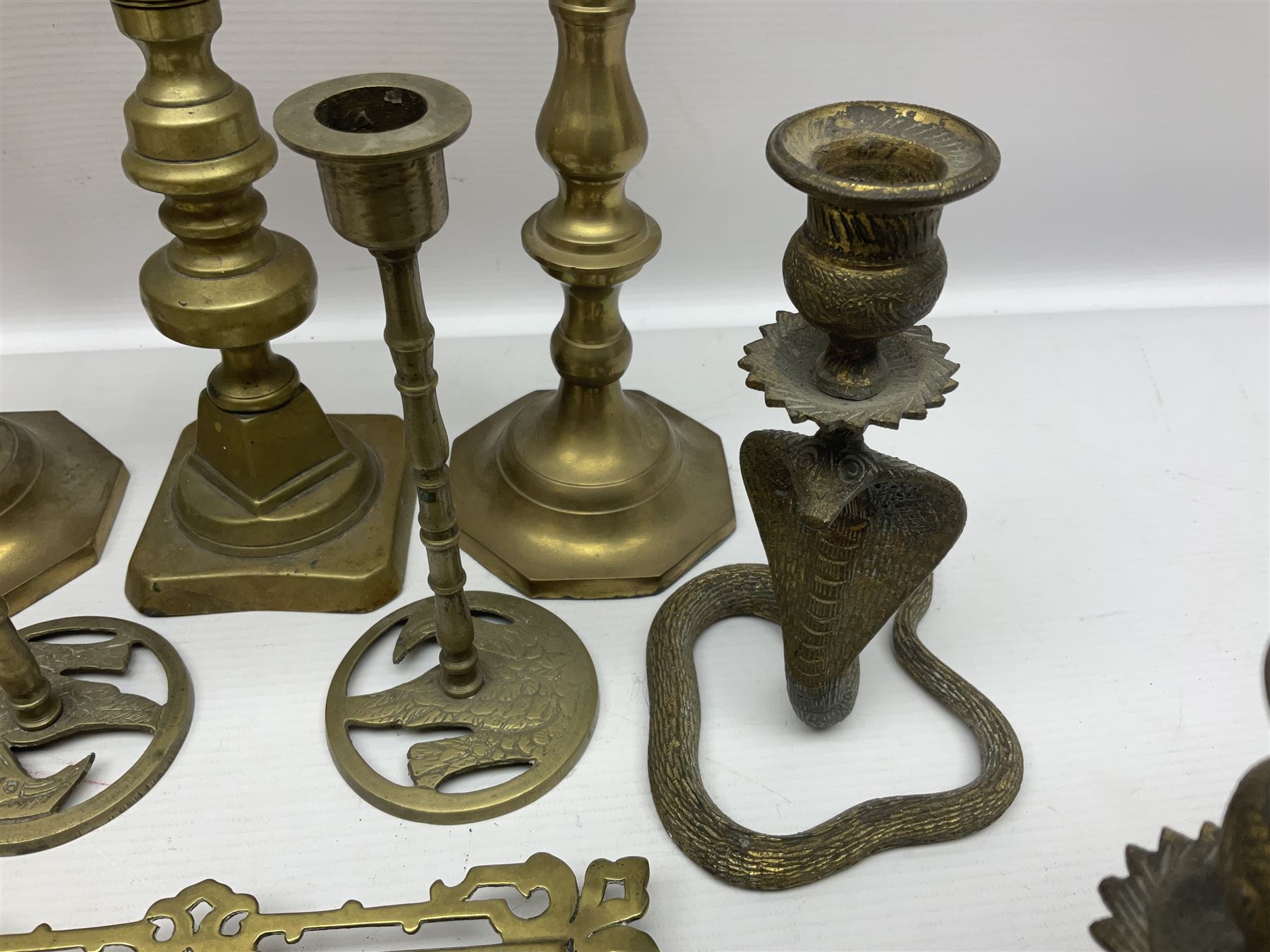 Brass inkstand, of square form, pierced, inset with blue and white ceramic inkwell to centre, together with a collation of brass candlesticks 