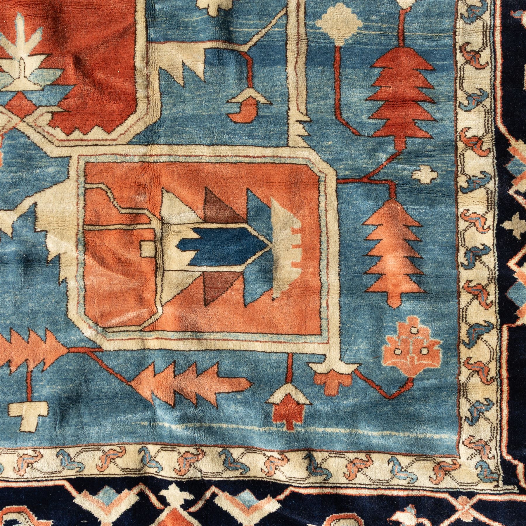 Exceptionally large Northwestern Persian Heriz, hand-knotted carpet, madder red field with a bold stepped medallion in indigo and ivory, and light blue spandrels within a dark indigo border of rosettes and angular vine motifs 




