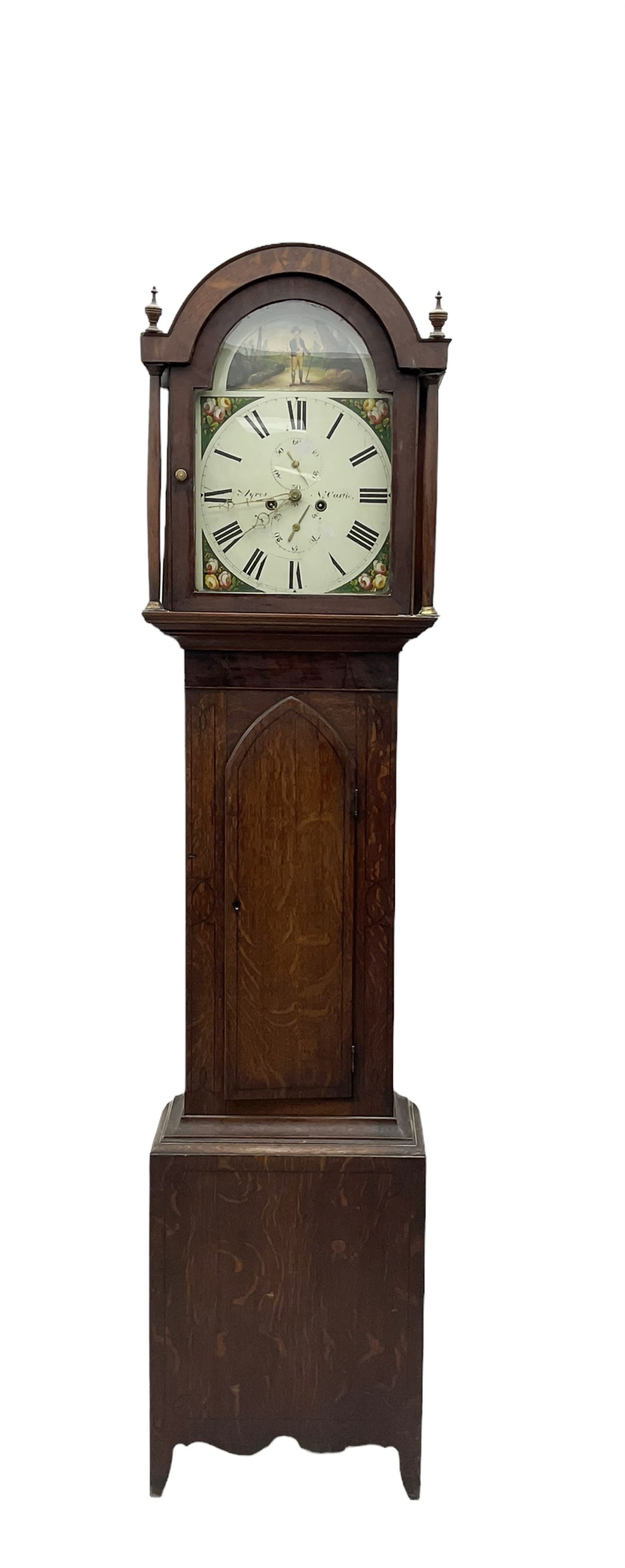 Ayers of Newcastle - 19th century oak cased 8 day longcase clock c1850, with a break-arch top and turned wooden finials, conforming hood door flanked by waisted pilasters and brass capitals, trunk door with an arched top, rectangular plinth with decorative base, painted dial with floral spandrels and a rural depiction to the arch, Roman numerals and minute track, with matching brass hands and subsidiary seconds and date dials, dial pinned directly to a rack striking movement, sounding the hours on a bell. With pendulum and weights.