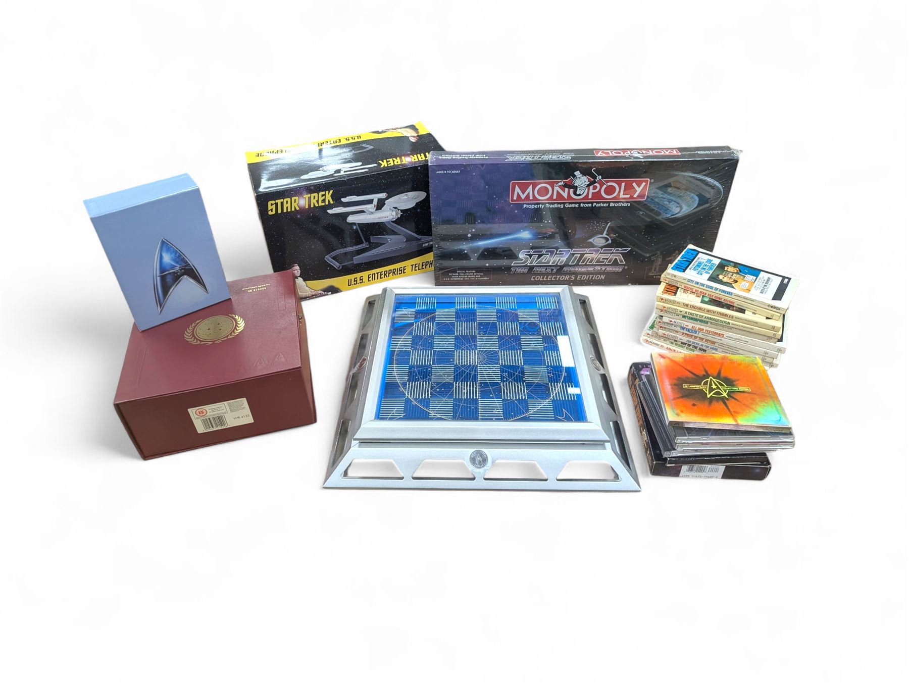 Star Trek Paramount Pictures Official Chess Set, incluidng glass board with removable lid, opening to reveal full set of gold and silver plated pewter figural chess pieces, with certificates, together with a Star Trek USS Enterprise Telephone, Star Trek Monopoly, 30th Anniversary DVD box set, Star Trek novels, DVDs, CDs, etc
