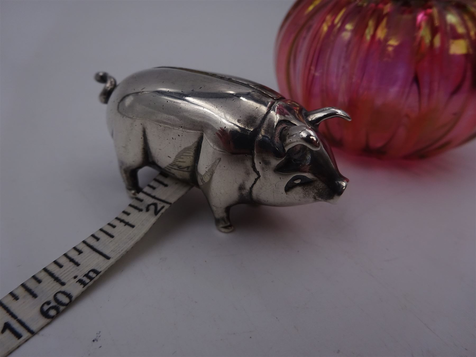 Modern novelty silver tape measure, in the form of a pig, hallmarked CME Jewellery Ltd, together with a silver mounted pink glass scent bottle, signed H. White to base, with silver collar hallmarked Laurence R Watson & Co, Birmingham 1996, scent bottle H12cm
