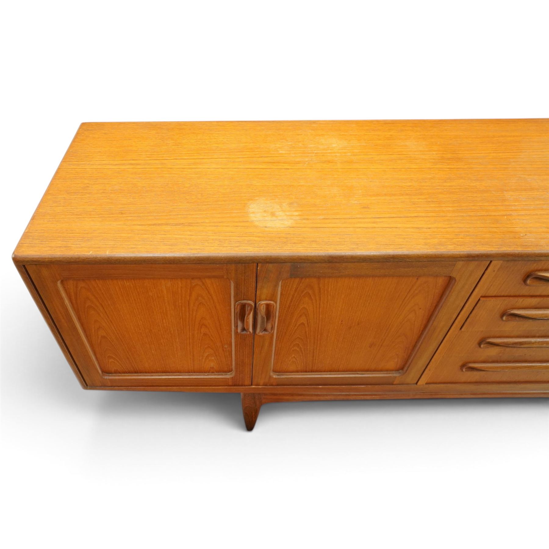 G-Plan - 'Fresco Long John' teak mid 20th century sideboard, a central bank of four drawers, flanked by twin cupboard doors, with recessed handles, on a tapering supports 