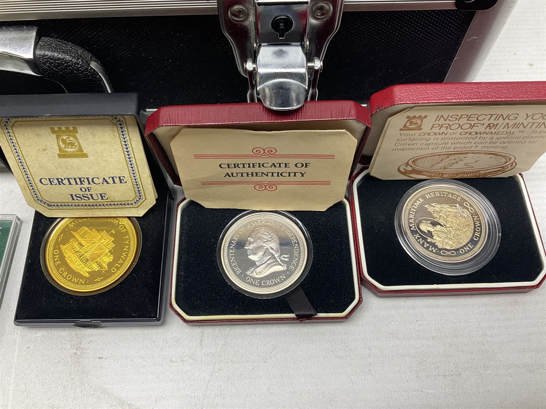 The Royal Mint United Kingdom 1977 silver proof two coin set, Queen Elizabeth II 2002 silver proof three coin set, comprising Bailiwick of Jersey, Bailiwick of Guernsey, and Alderney five pound coins, 'First Coinage of the British Virgin Islands' proof set, 1997 1/10 ounce fine silver Britannia, two King George V 1935 'Rocking Horse' crowns, various Isle of Man commemorative crowns, etc., house in a hard shell carry case