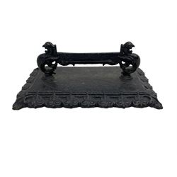 Victorian black-painted cast iron boot scraper, mythical ornithomorphic cast supports, on rectangular plinth with stylised leaf moulded edge 