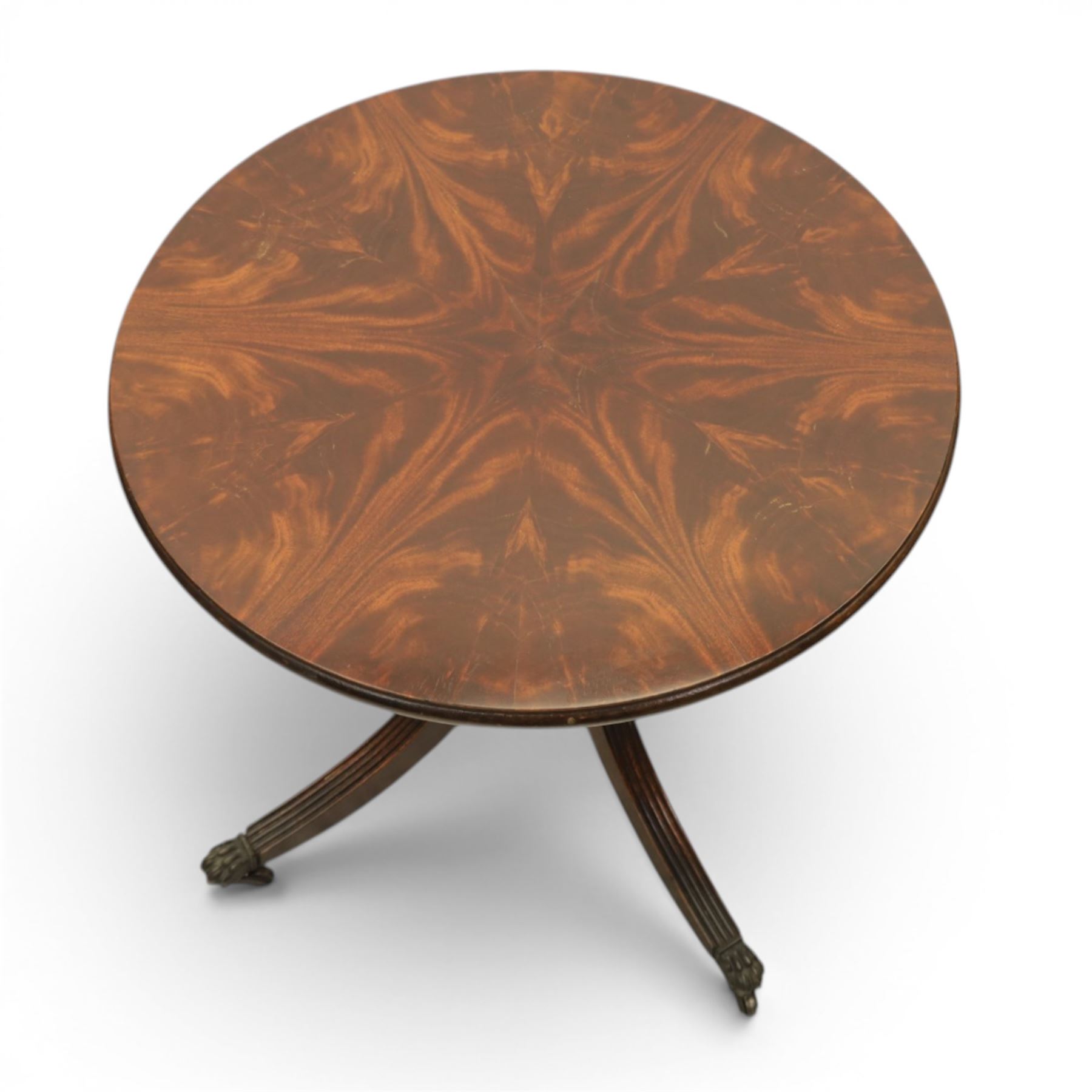 Pair of Georgian design flame mahogany wine tables, circular book-matched veneered tops with moulded edges, on turned pedestals and four reeded downswept supports terminating in brass caps and castors