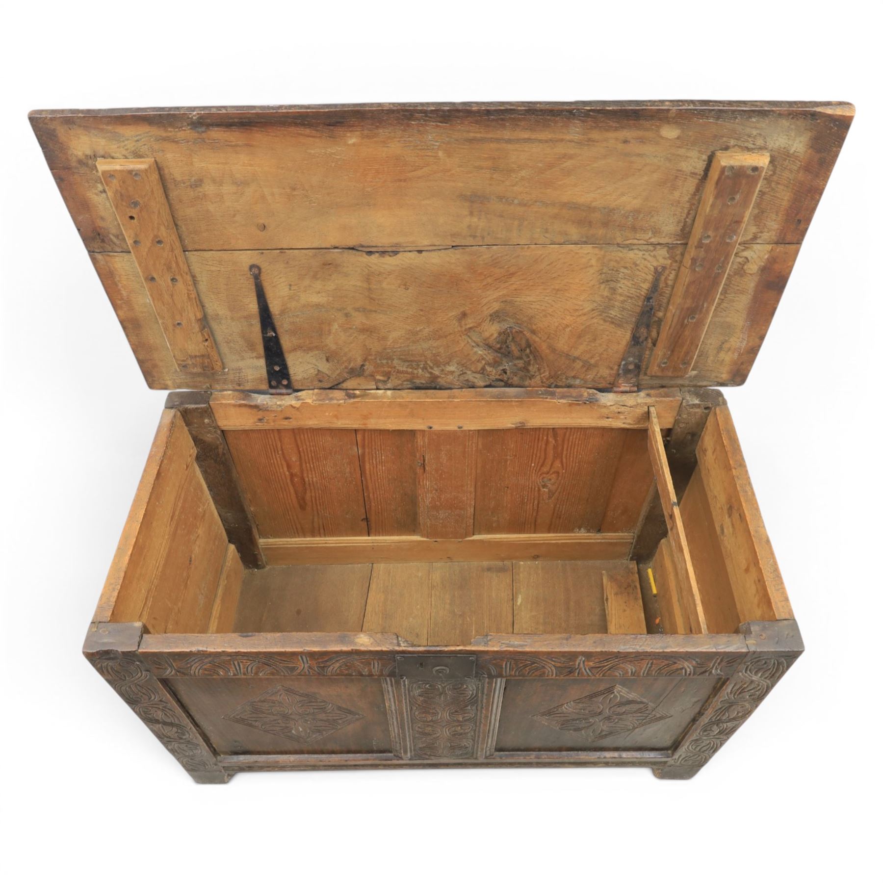 18th century oak coffer with carved frieze and rails, rectangular plank top with iron strap hinges, raised on stile supports